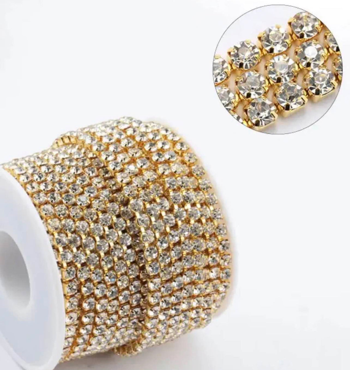 Gold rhinestone trim ribbon spool with a circular inset showing a close-up of the crystal-embellished gold settings on a white background.