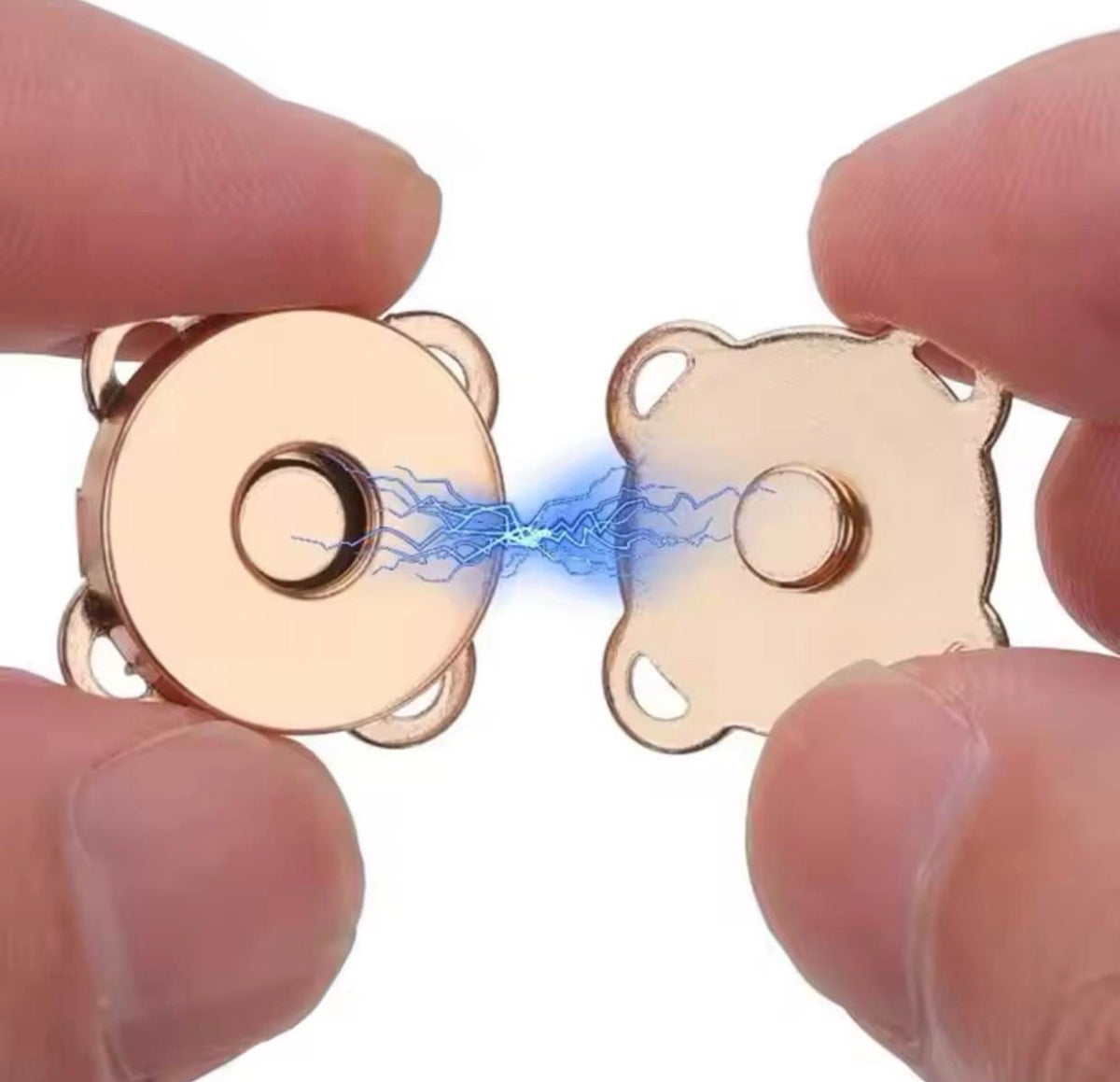Two small round metallic magnetic components held between fingers against a white background, with a blue electric effect graphic between them.