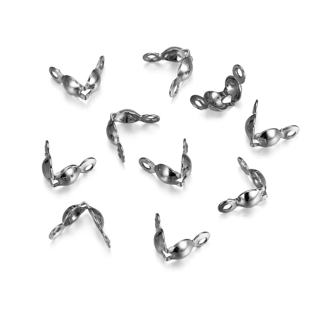 Ten small polished silver metal lobster clasp findings scattered on a clean white background.