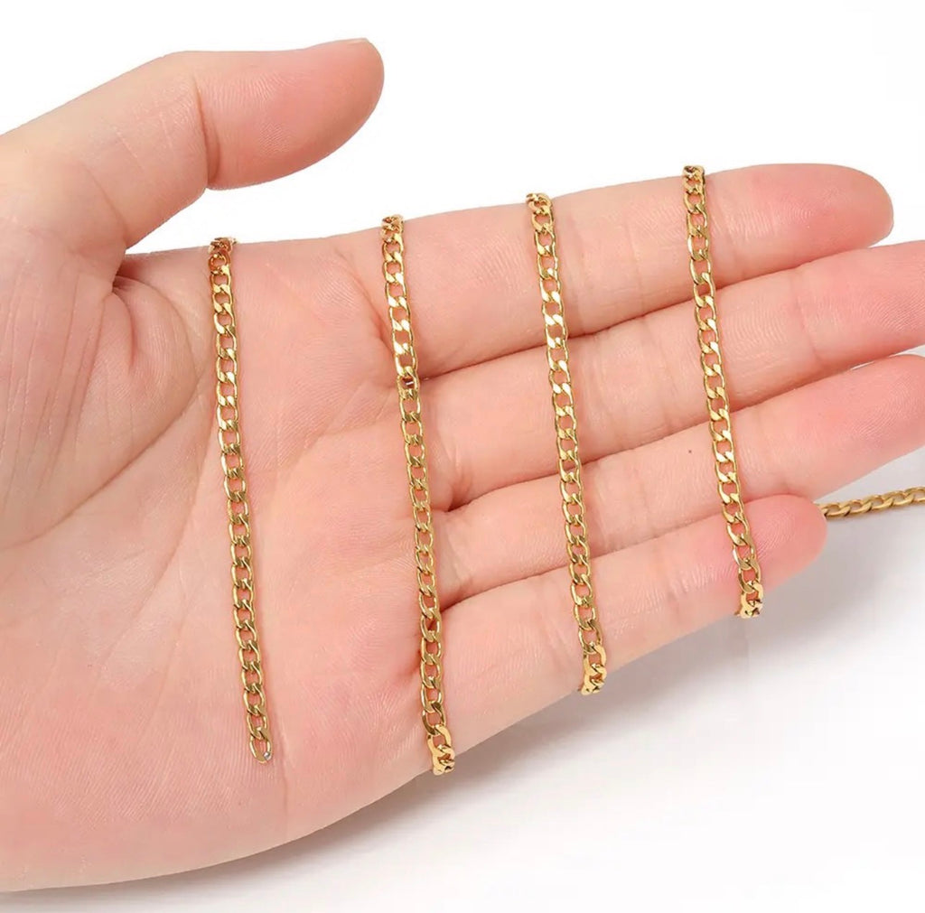 Three gold-tone chain necklaces of different lengths draped over an open hand against a plain white background.