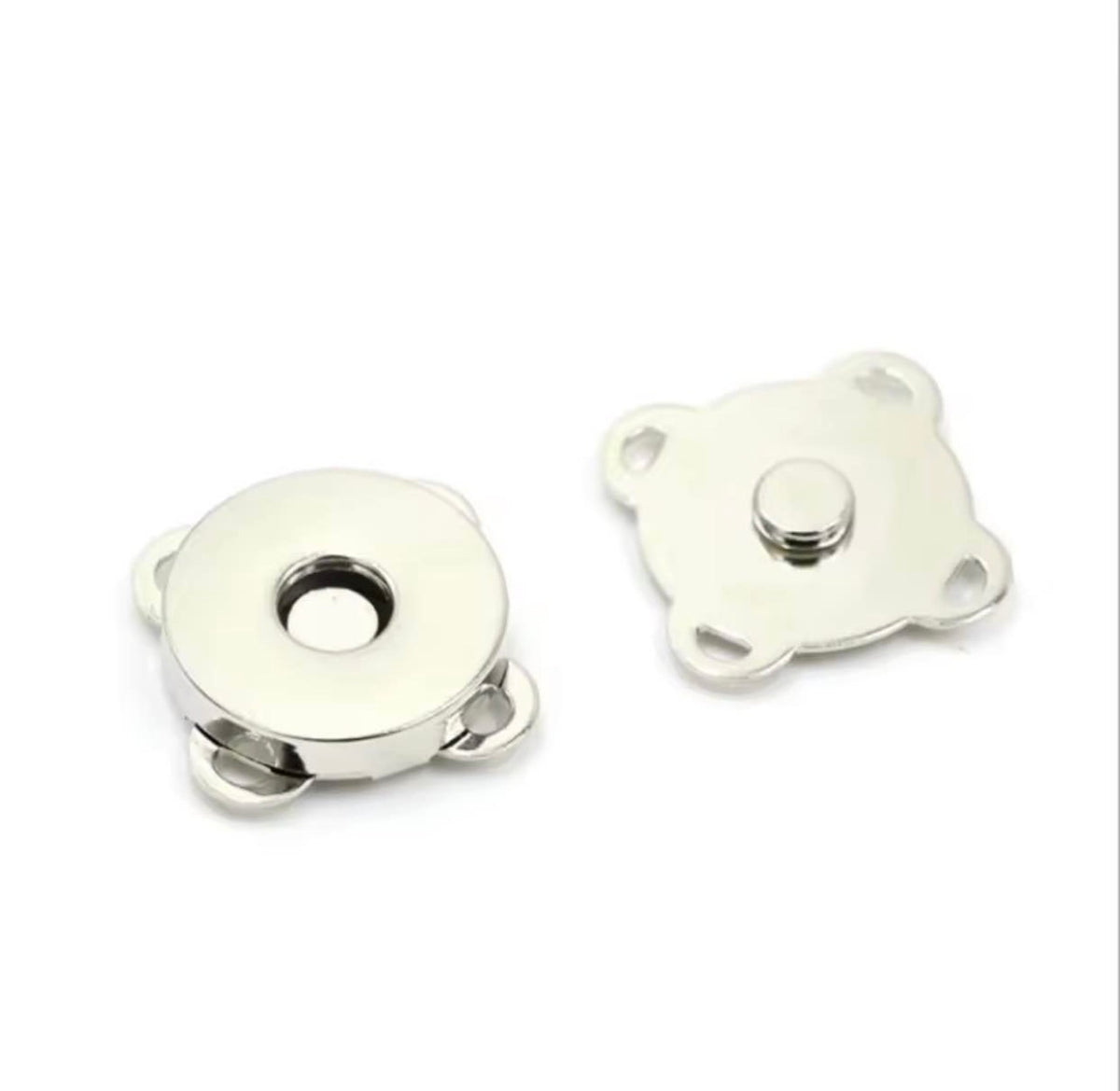 Two small silver metal snap button components on a plain white background, showing the front and back views of the magnetic snap fastener.