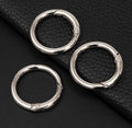 Three silver rings on a black leather surface
