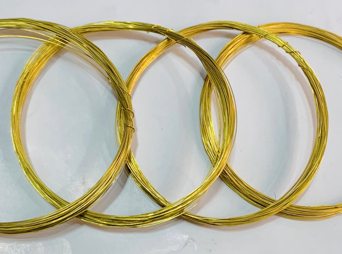 Four coiled gold wire loops arranged overlapping on a plain white background.