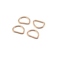 Four small rose gold metal loop clasps arranged on a plain white background.