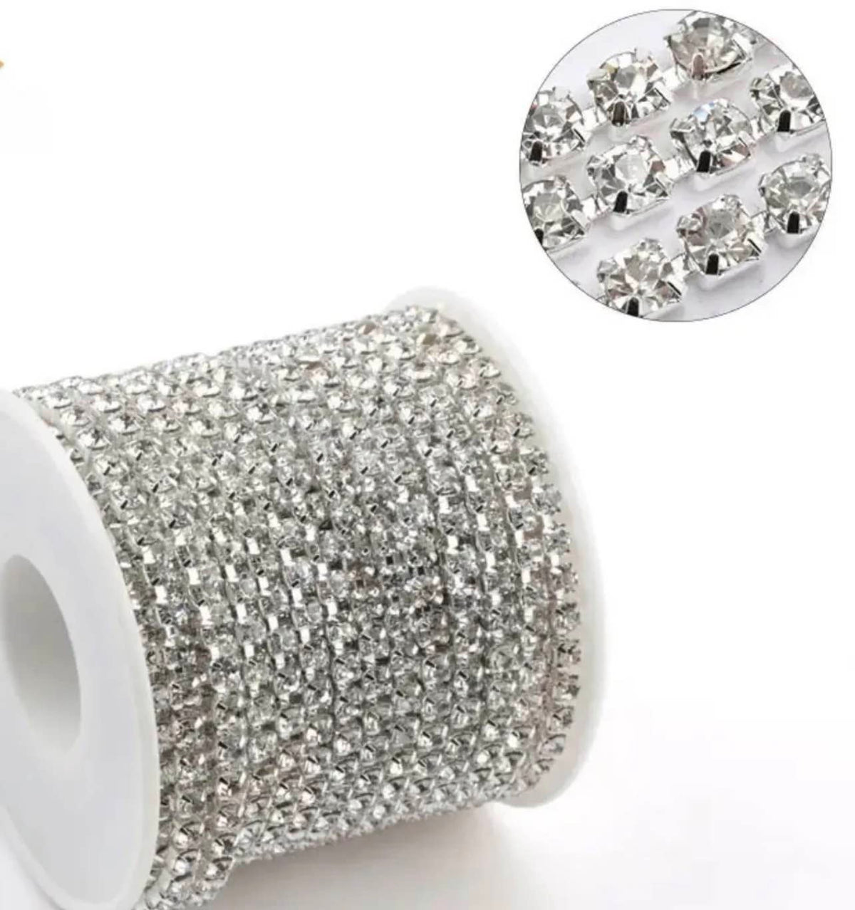 A spool of silver rhinestone trim with a circular inset showing a close-up of the individual clear faceted stones on a white background.